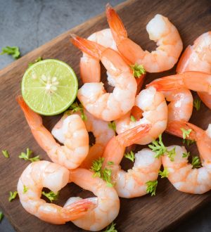 Shrimp peeled on wooden cutting board dark background dining table food, Fresh shrimps prawns seafood lemon lime with herbs and spice, top view